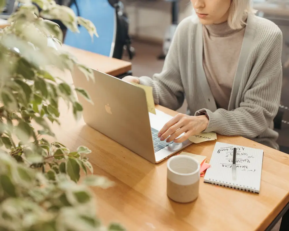 A woman working at a laptop in a bright office